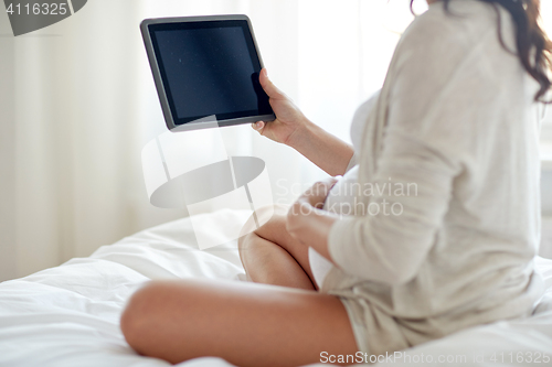 Image of close up of pregnant woman with tablet pc at home