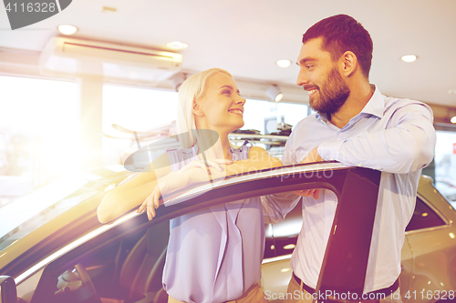 Image of happy couple buying car in auto show or salon