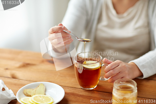 Image of close up of ill woman drinking tea with lemon