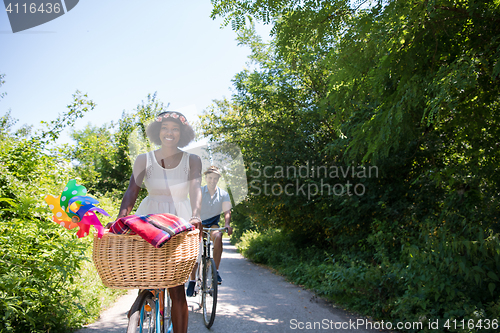 Image of Young  couple having joyful bike ride in nature