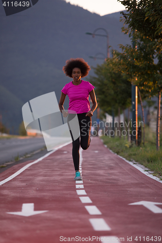 Image of a young African American woman jogging outdoors