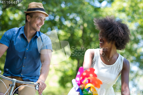 Image of Young  couple having joyful bike ride in nature