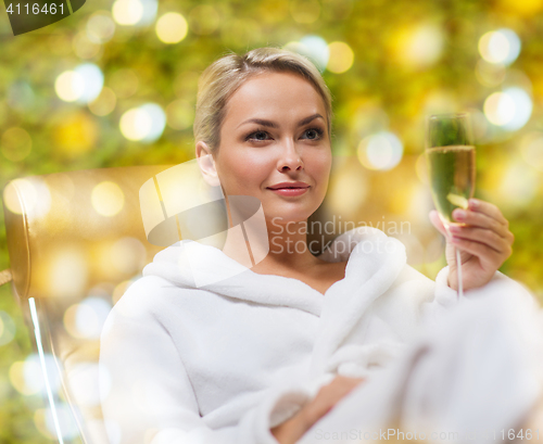 Image of beautiful young woman drinking champagne at spa