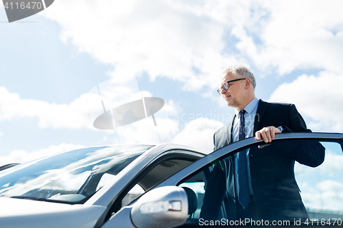 Image of senior businessman getting into car