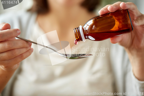 Image of woman pouring medication from bottle to spoon