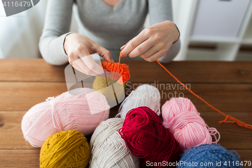 Image of woman pulling yarn up into ball