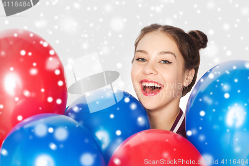 Image of happy teenage girl with helium balloons over snow