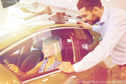 Image of happy couple buying car in auto show or salon