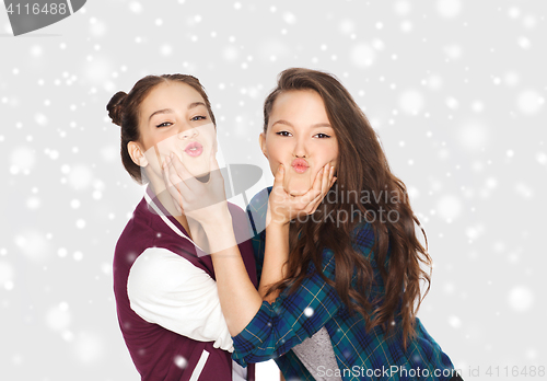 Image of happy smiling teenage girls having fun over snow