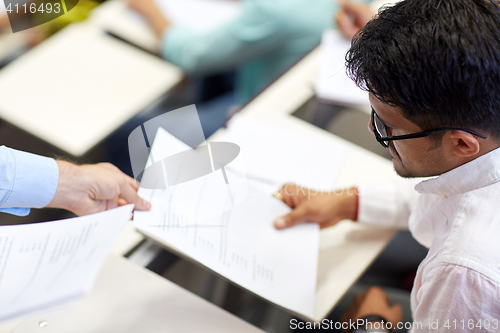 Image of teacher giving exam test to student at lecture