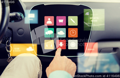 Image of close up of hand and menu icons on car computer