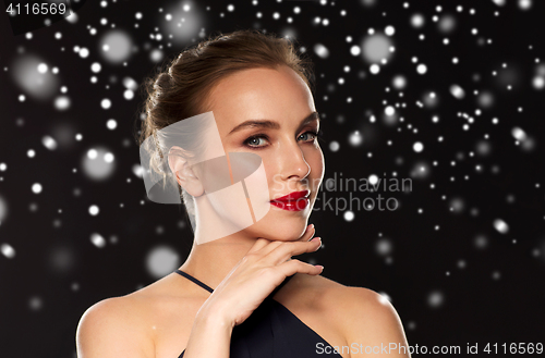 Image of beautiful woman over black background and snow