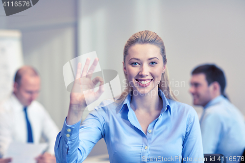 Image of group of smiling businesspeople meeting in office