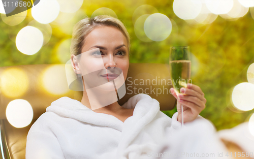 Image of beautiful young woman drinking champagne at spa