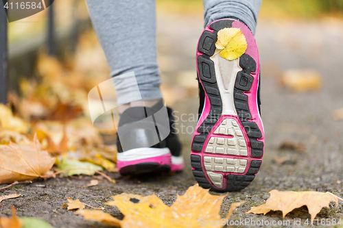 Image of close up of woman feet wearing sneakers in autumn