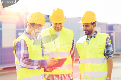 Image of smiling builders in hardhats with tablet pc