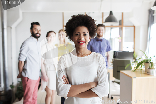 Image of happy young woman over creative team in office