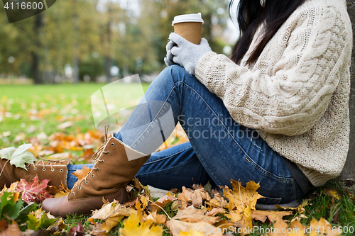 Image of close up of  woman drinking coffee in autumn park