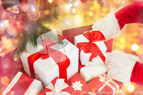 Image of close up of santa claus with presents over lights