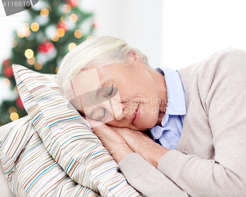 Image of happy senior woman sleeping on pillow at home