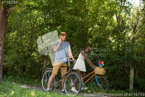 Image of Young  couple having joyful bike ride in nature