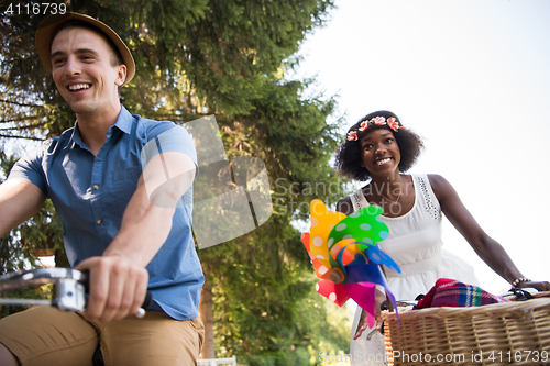 Image of Young  couple having joyful bike ride in nature