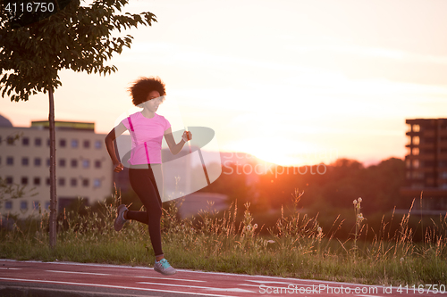 Image of a young African American woman jogging outdoors