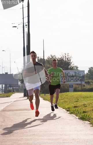 Image of Two young men jogging through the city