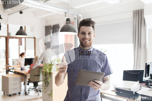 Image of happy creative male office worker with tablet pc