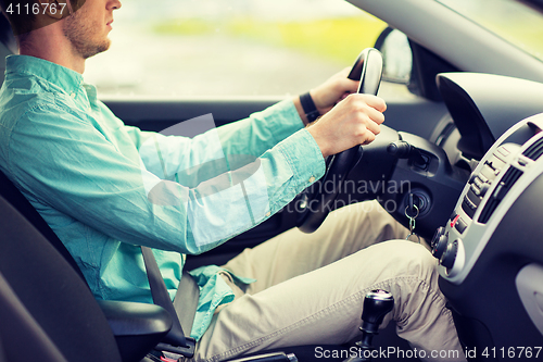 Image of close up of young man driving car