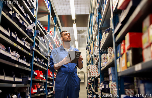 Image of auto mechanic or smith with tablet pc at workshop