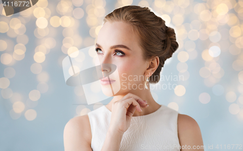 Image of beautiful woman in white with diamond earring