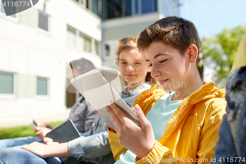 Image of happy friends or students with tablet pc outdoors