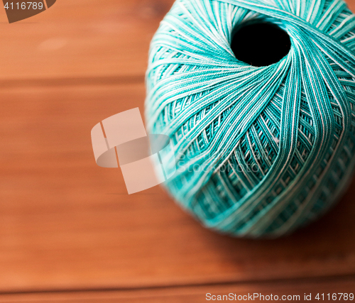 Image of close up of turquoise knitting yarn ball on wood