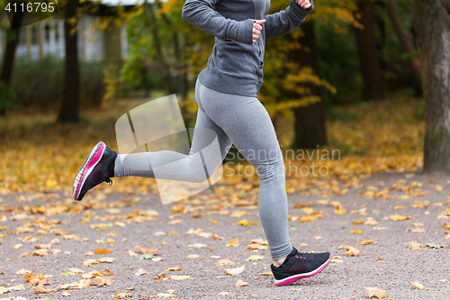 Image of close up of young woman running in autumn park