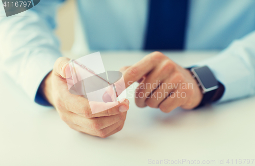 Image of close up of hands with smart phone and watch