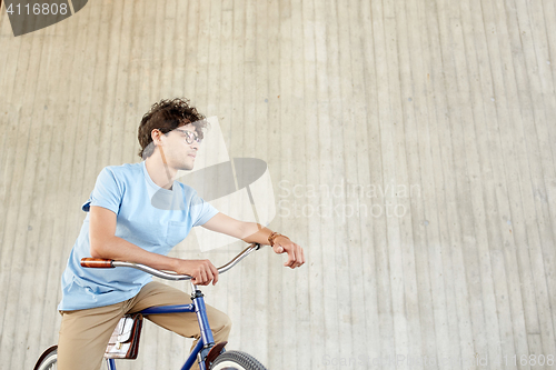 Image of young hipster man riding fixed gear bike