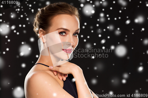 Image of beautiful woman over black background and snow