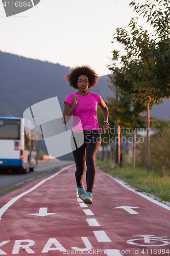 Image of a young African American woman jogging outdoors