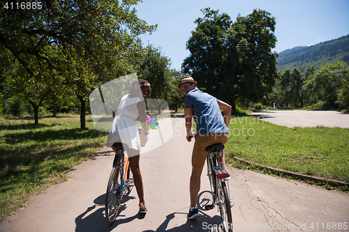 Image of Young  couple having joyful bike ride in nature