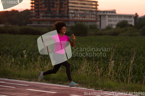 Image of a young African American woman jogging outdoors
