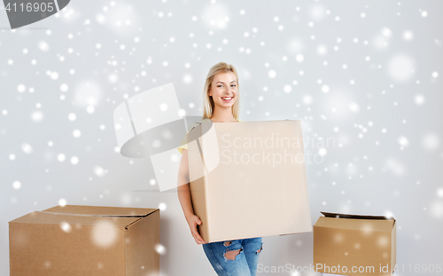 Image of smiling young woman with cardboard box at home