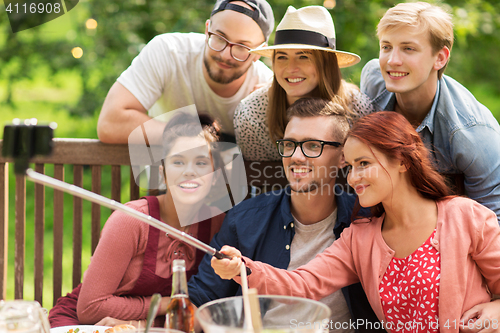 Image of friends taking selfie at party in summer garden