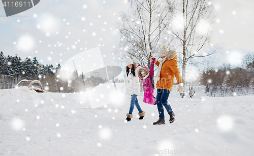 Image of happy family in winter clothes walking outdoors