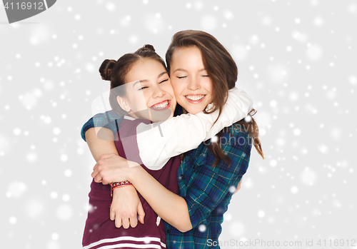 Image of happy smiling teenage girls hugging over snow
