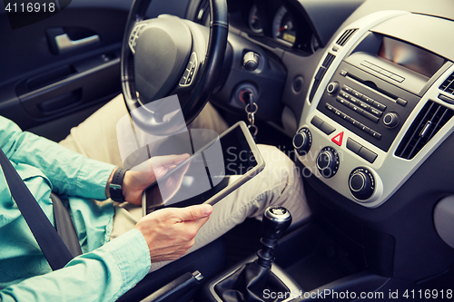 Image of close up of young man with tablet pc driving car