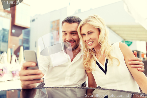 Image of couple taking selfie with smatphone at restaurant