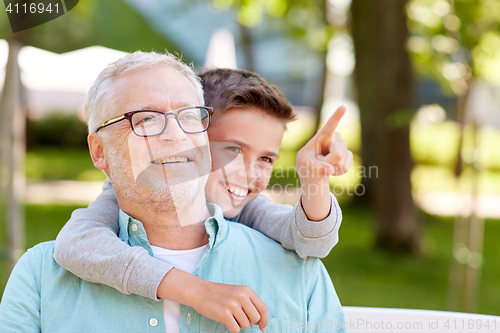 Image of grandfather and boy pointing finger at summer park