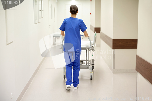 Image of nurse carrying hospital gurney to emergency room