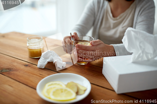 Image of ill woman drinking tea with lemon and honey